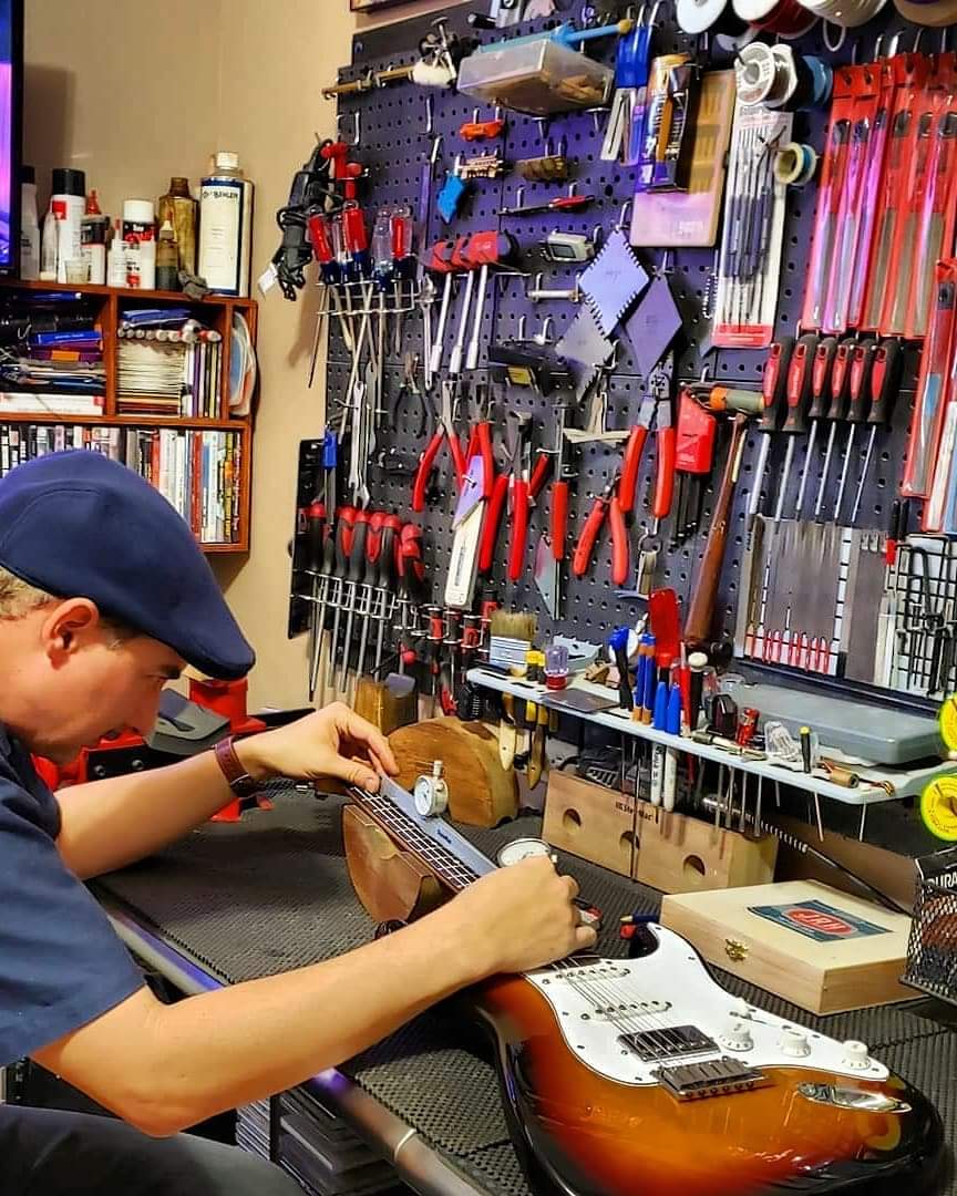 Joseph Robles trabajando con precisión en una guitarra eléctrica en su taller de JRH Guitar Repair